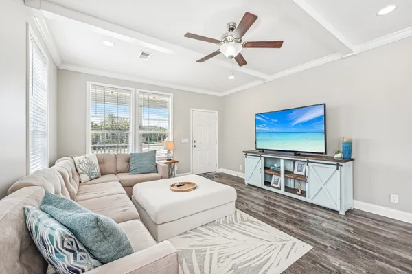 a living room with furniture a ceiling fan and a rug