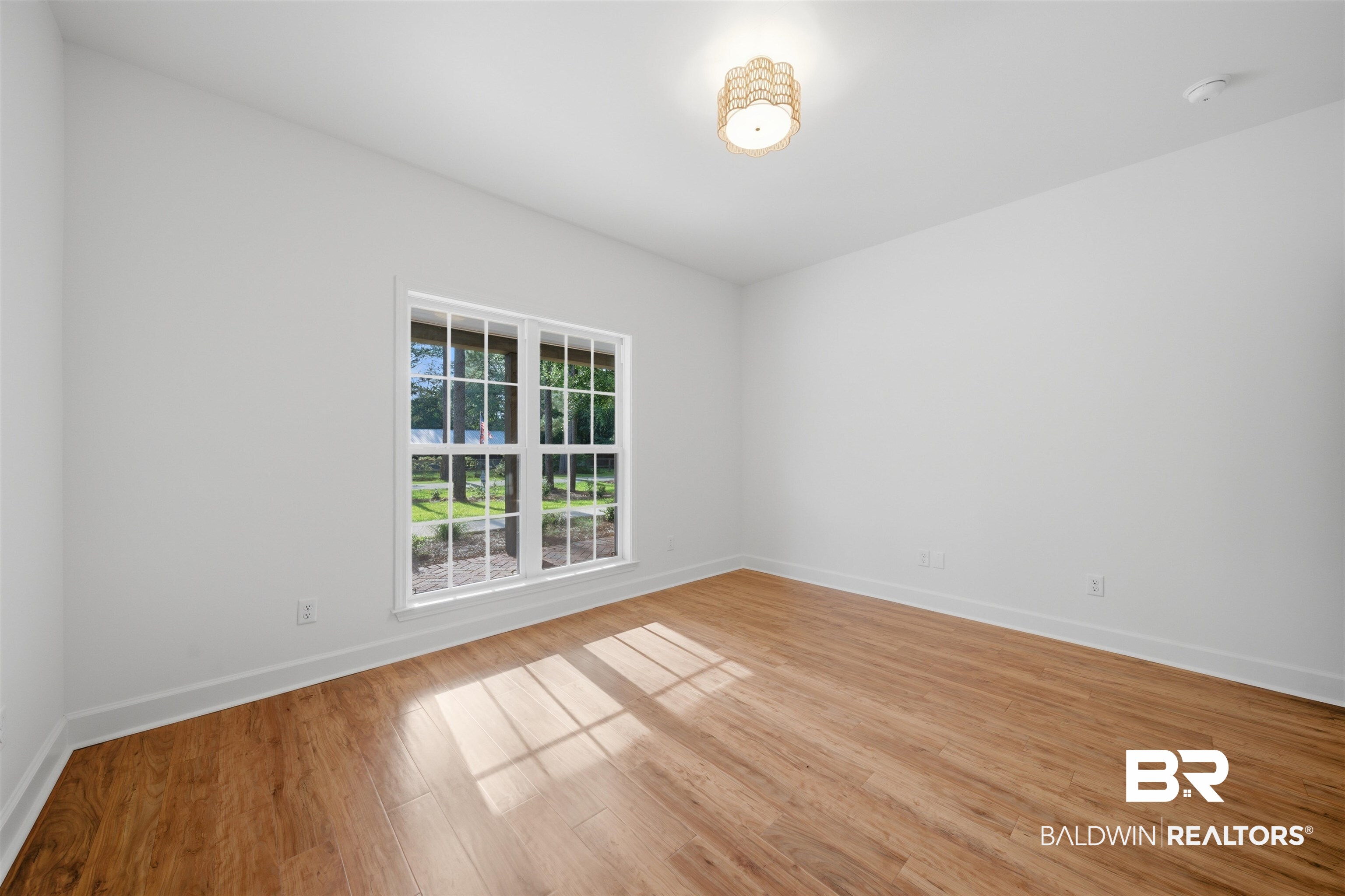14128 Jackson Lane Foley, AL 36535 - Photo 27 of 36 Bright room featuring wood-finish flooring, white walls, and a multi-pane window