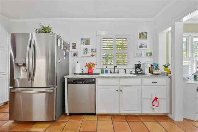 a kitchen with granite countertop a refrigerator and a sink