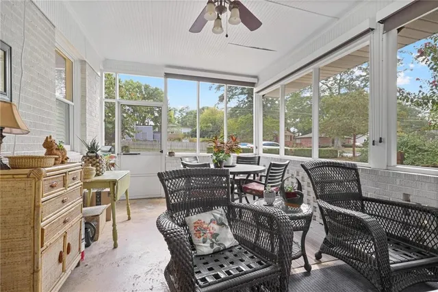 a dining room with furniture a chandelier and a large window