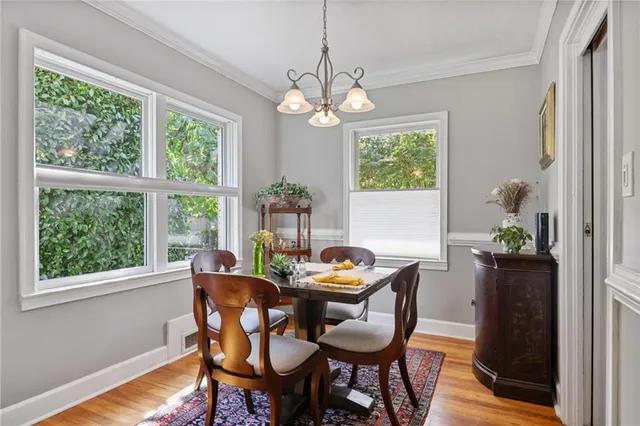 a dining room with furniture a large window and wooden floor