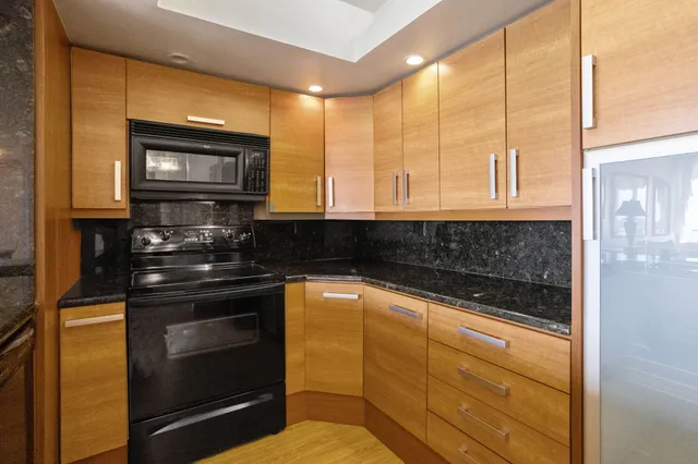 a kitchen with stainless steel appliances granite countertop a stove and a microwave