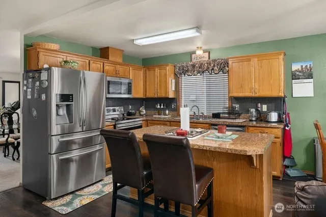 a kitchen with stainless steel appliances granite countertop a stove refrigerator sink and cabinets