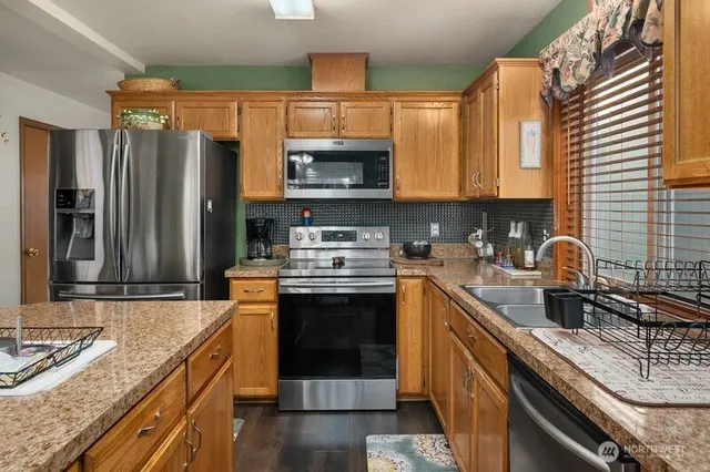 a kitchen with granite countertop a sink stove and refrigerator