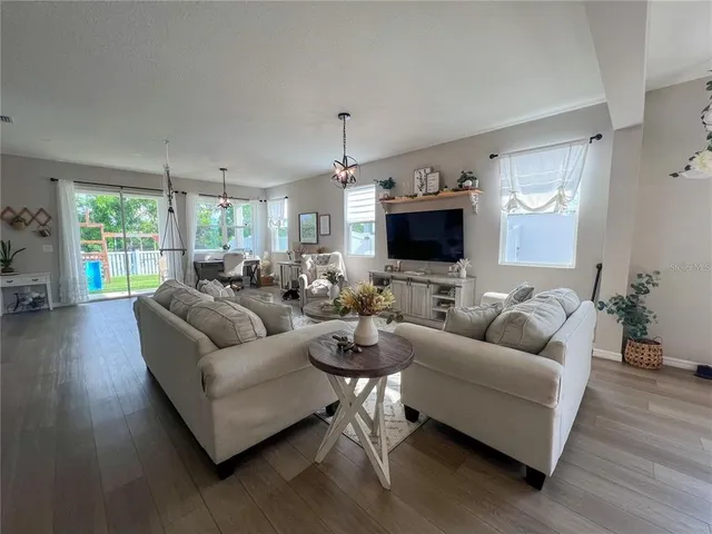 a living room with furniture a large window and a flat screen tv