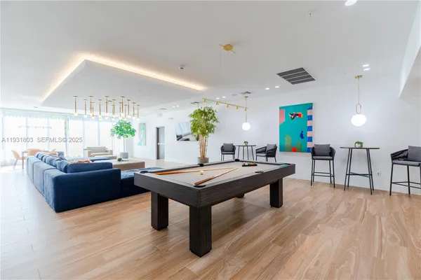 a living room with furniture a wooden floor and potted plant