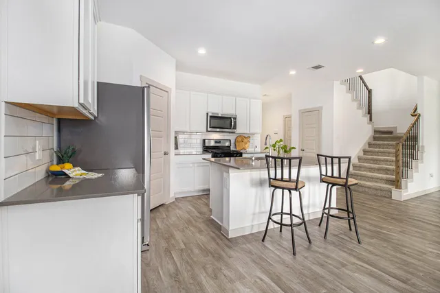 a kitchen with stainless steel appliances a refrigerator a stove a sink dishwasher and a stove with wooden floor