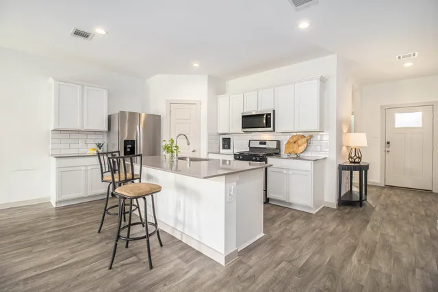 a kitchen with white cabinets and stainless steel appliances