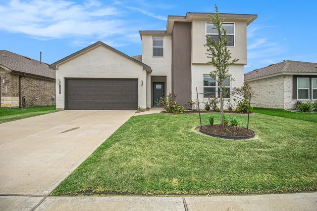 a front view of a house with a yard and garage