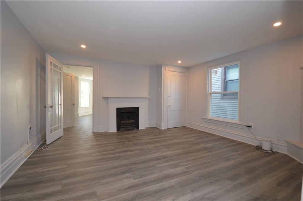 115 Meade Avenue Pittsburgh, PA 15202 - Photo 13 of 38 an empty room with wooden floor and fireplace