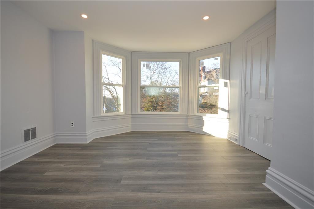 115 Meade Avenue Pittsburgh, PA 15202 - Photo 17 of 38 a view of an empty room with a window and wooden floor