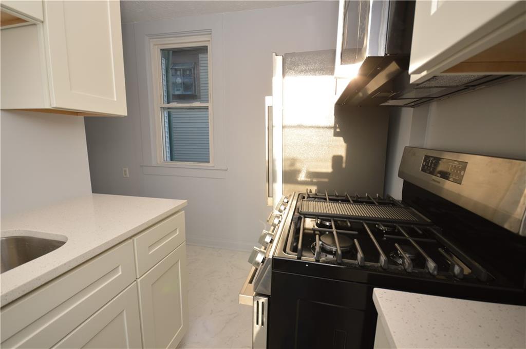 115 Meade Avenue Pittsburgh, PA 15202 - Photo 9 of 38 a kitchen with a stove and white cabinets