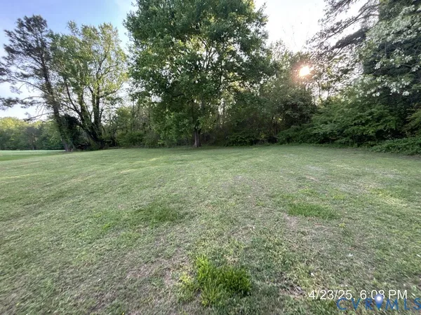 a view of a field with trees in the background