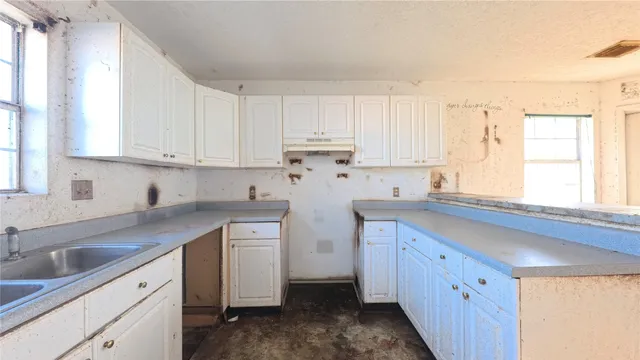 a kitchen with stainless steel appliances granite countertop a sink and cabinets with wooden floor
