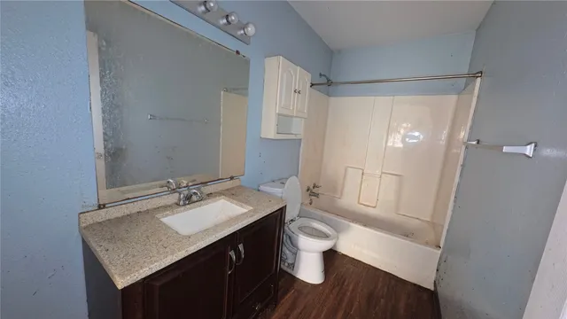 a bathroom with a granite countertop sink toilet a mirror a vanity and shower