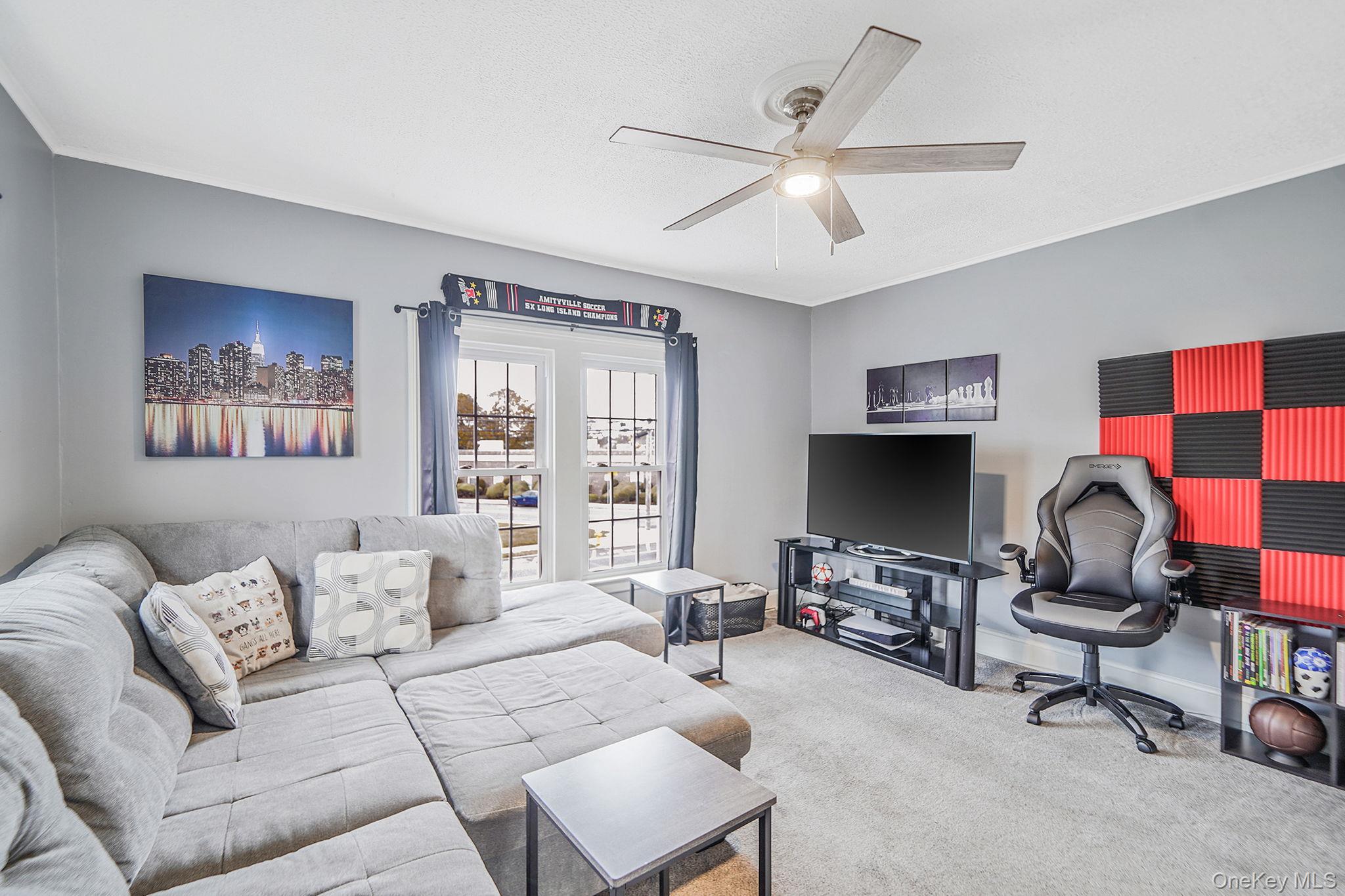 45 Maple Avenue Patchogue, NY 11772 - Photo 19 of 30 a living room with furniture a chandelier and a window