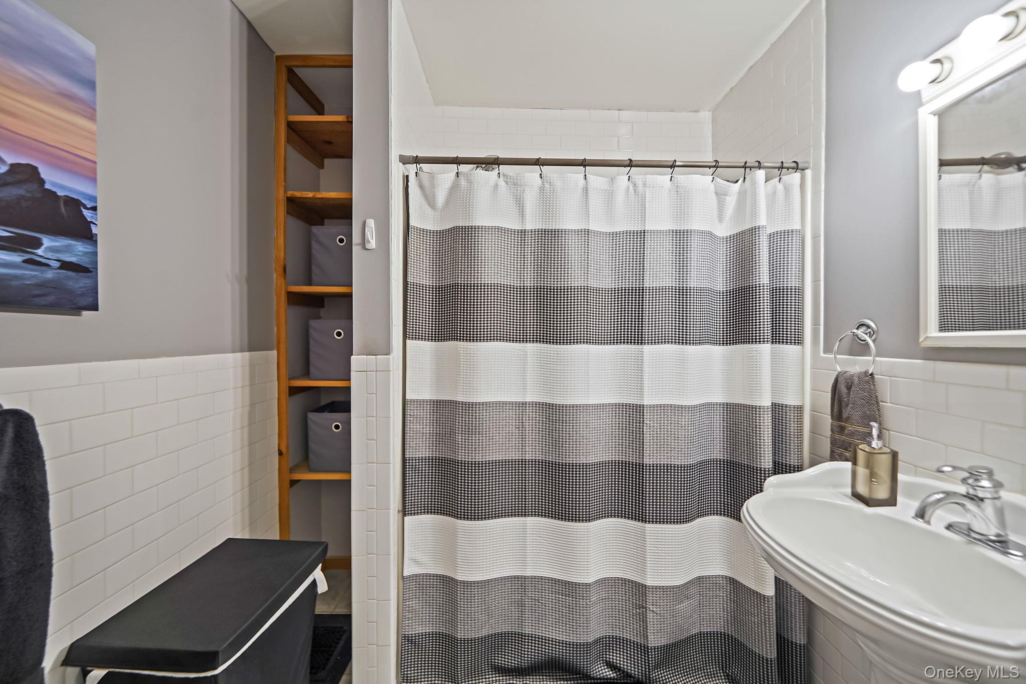 45 Maple Avenue Patchogue, NY 11772 - Photo 21 of 30 a bathroom with a sink a toilet and shower curtain