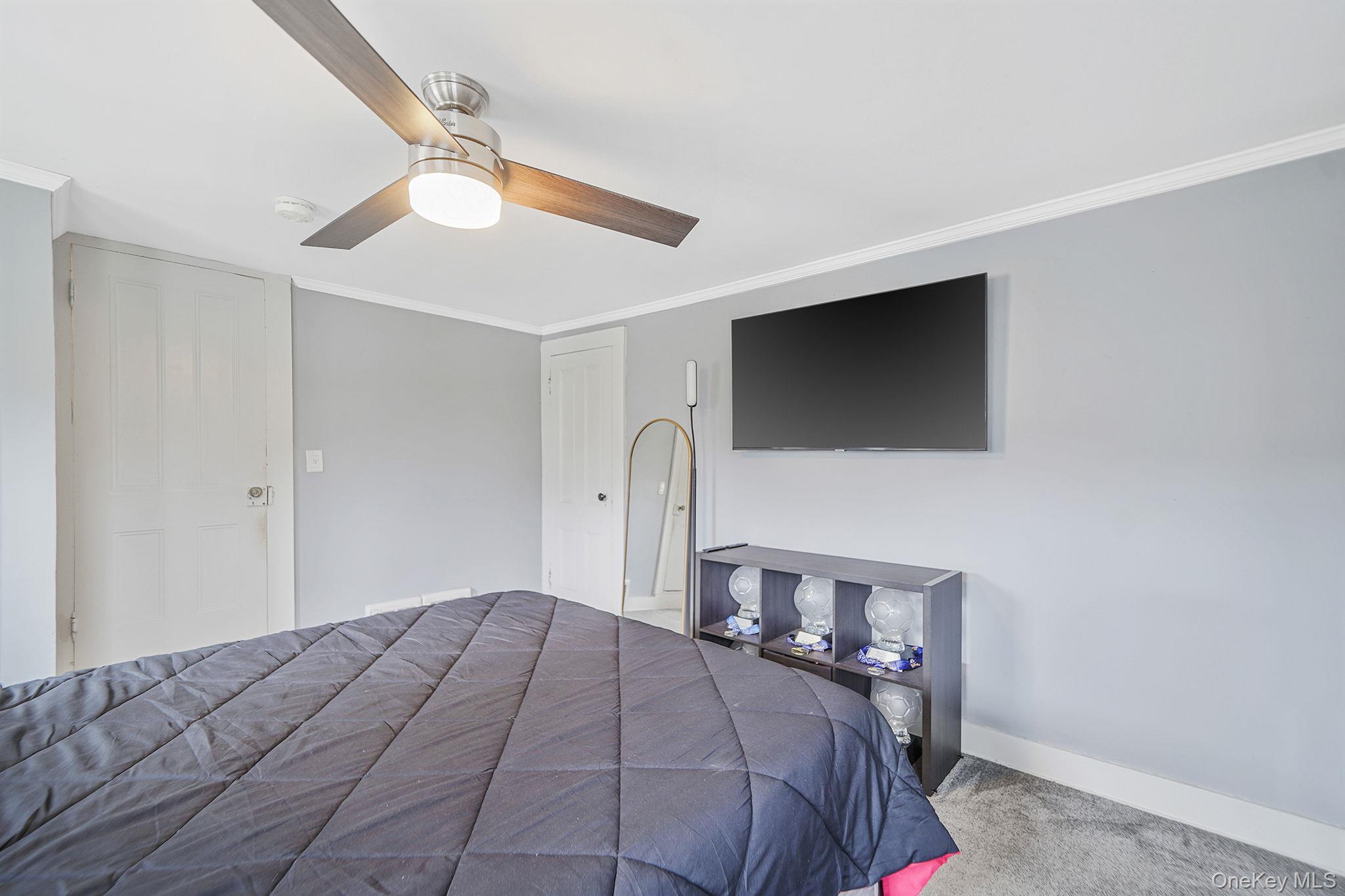 45 Maple Avenue Patchogue, NY 11772 - Photo 23 of 30 a bedroom with a bed and a flat screen tv