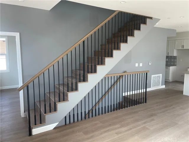 a view of staircase with railing and white walls