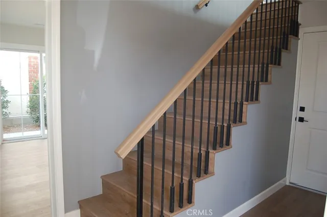 a view of staircase with wooden floor and white walls