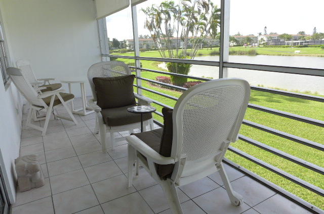 2079 Exeter Boca Raton, FL 33434 - Photo 16 of 17 a view of a chairs and table in patio with a lake view