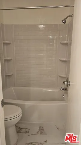 a bathroom with a toilet and shower