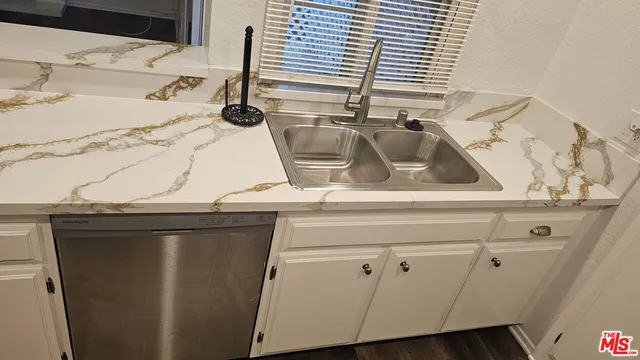 a view of an empty room with wooden floor and a fireplace
