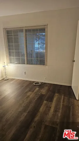 an empty room with wooden floor and a window