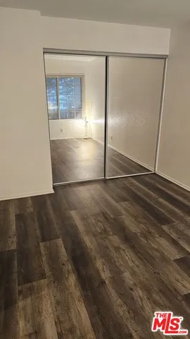 an empty room with wooden floor and door
