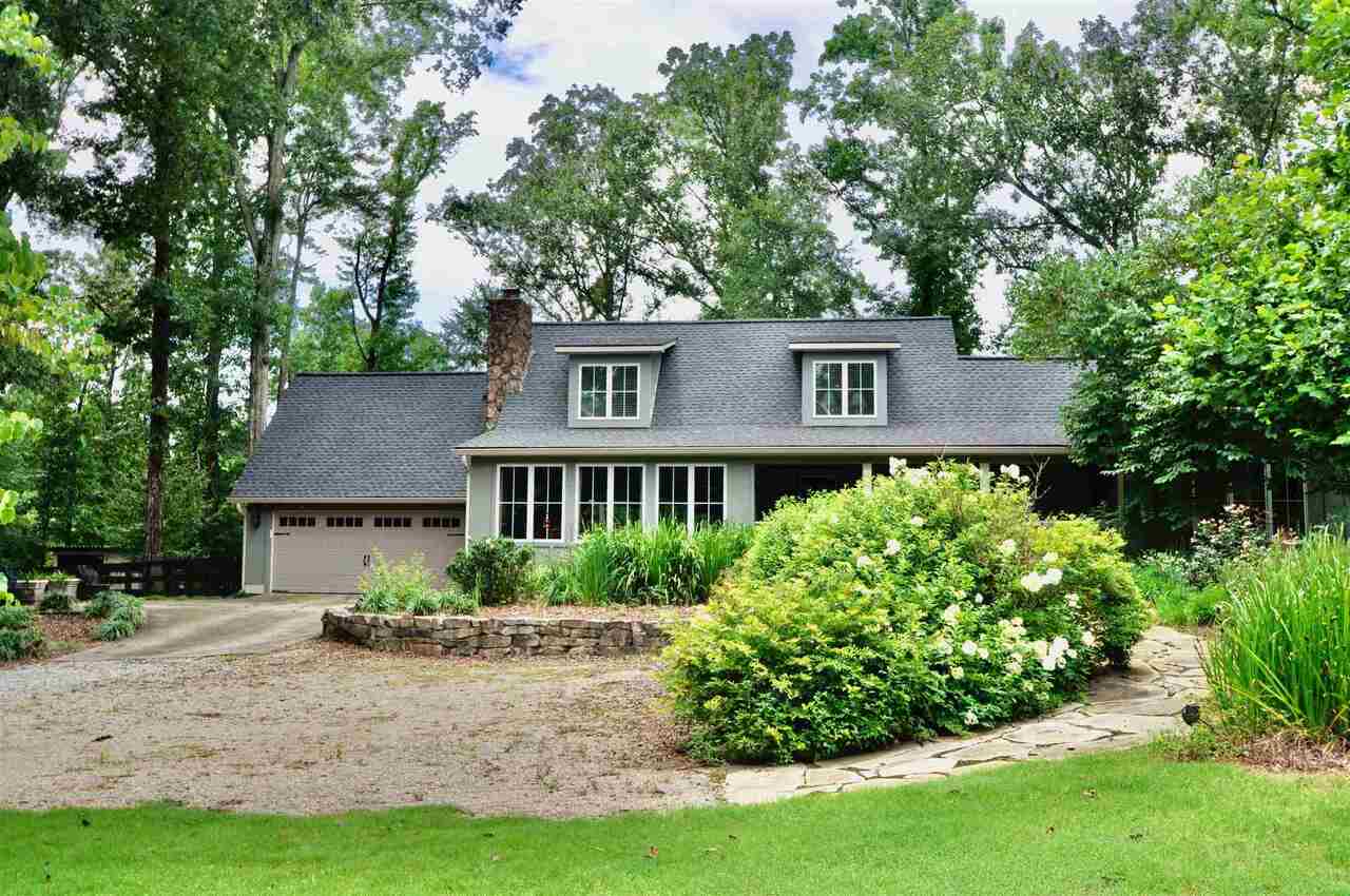 a front view of a house with a yard and trees