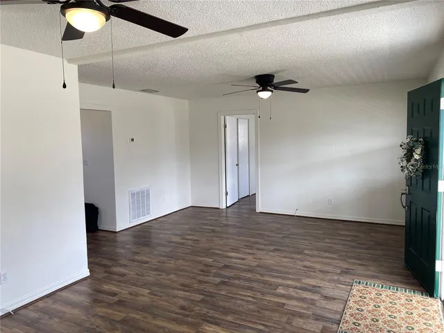 a view of an empty room with a ceiling fan