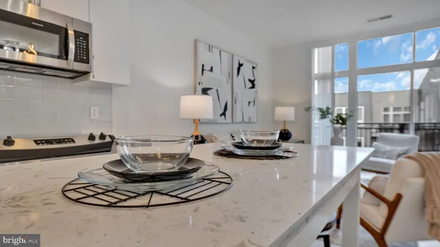 a kitchen with a stove and a view of living room