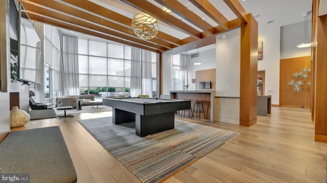 a large living room with stainless steel appliances kitchen island granite countertop a large window and a counter space