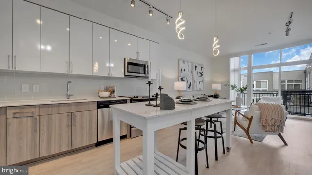 a kitchen with stainless steel appliances kitchen island granite countertop a sink a stove a table and chairs