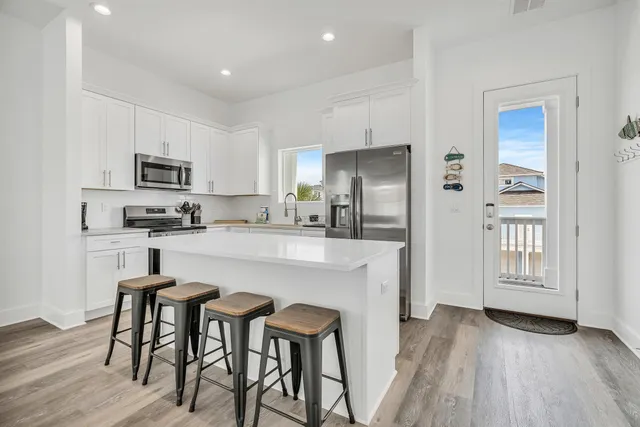 a kitchen with white cabinets stainless steel appliances and sink