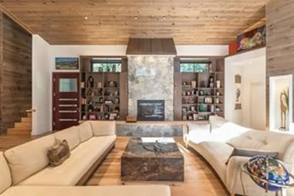 a living room with fireplace furniture and a large window