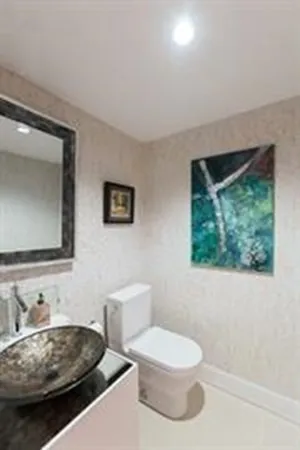 a bathroom with a toilet a sink and mirror