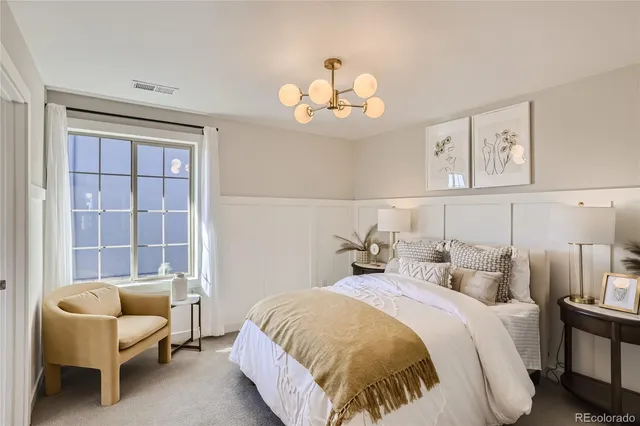 a spacious bedroom with a bed and a chair