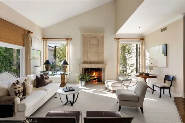 a living room with furniture fireplace and a large window
