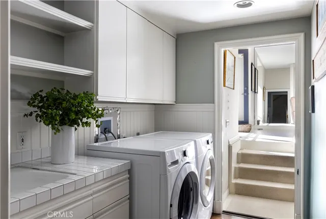 a view of an empty room with wooden floor and a kitchen