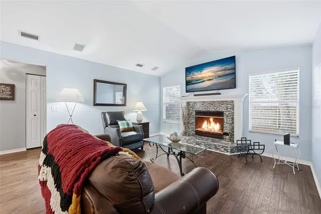 a living room with furniture a flat screen tv and a fireplace