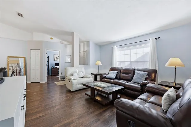 a living room with furniture and wooden floor