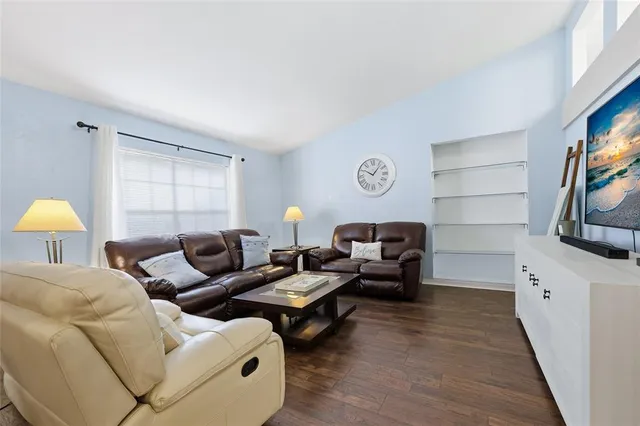 a living room with furniture a flat screen tv and a window