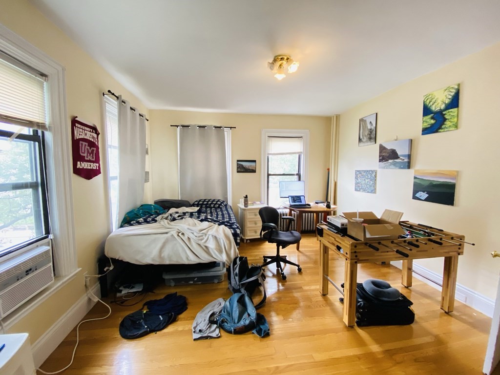 a bedroom with furniture and a wooden floor