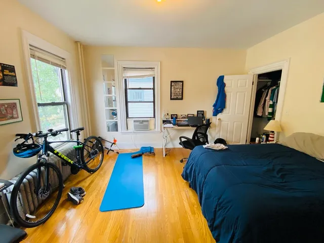 a bed sitting in a bedroom next to a window