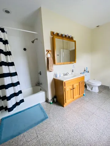 a spacious bathroom with a tub sink and toilet