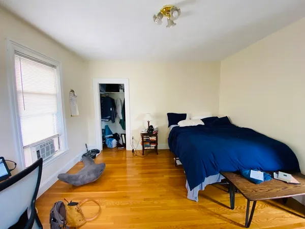 a bed sitting in a bedroom next to a window