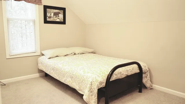 a bed sitting in a bedroom next to a window