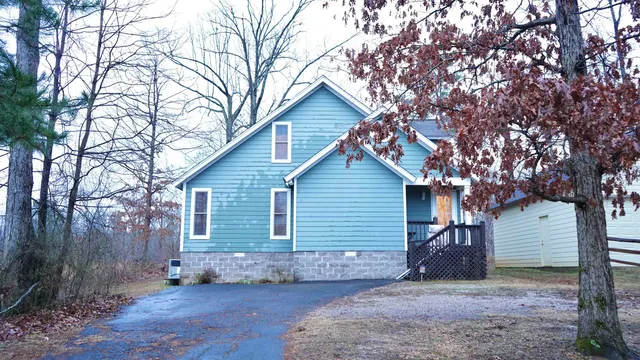 a view of a house with a yard and tree