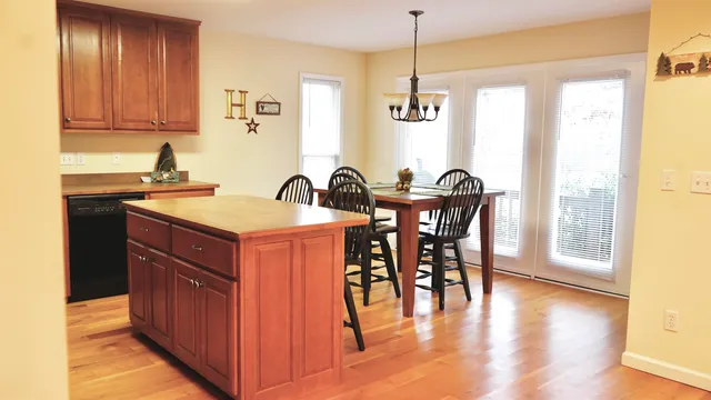 a kitchen with a stove a sink and island with wooden floor